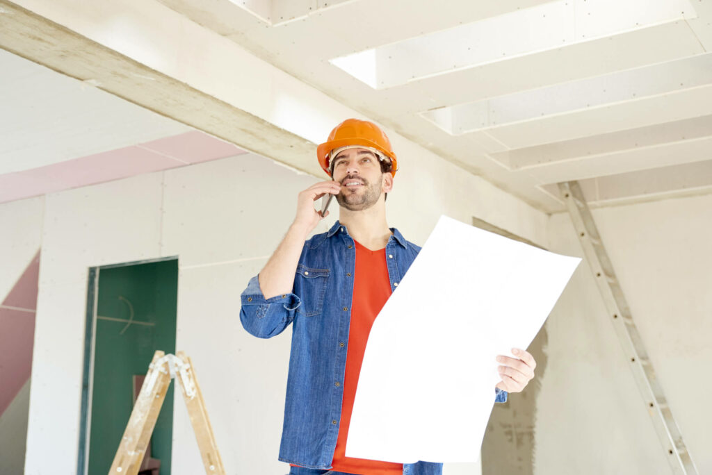 A Contractor Holding Blueprints and Participating in Home Addition Planning